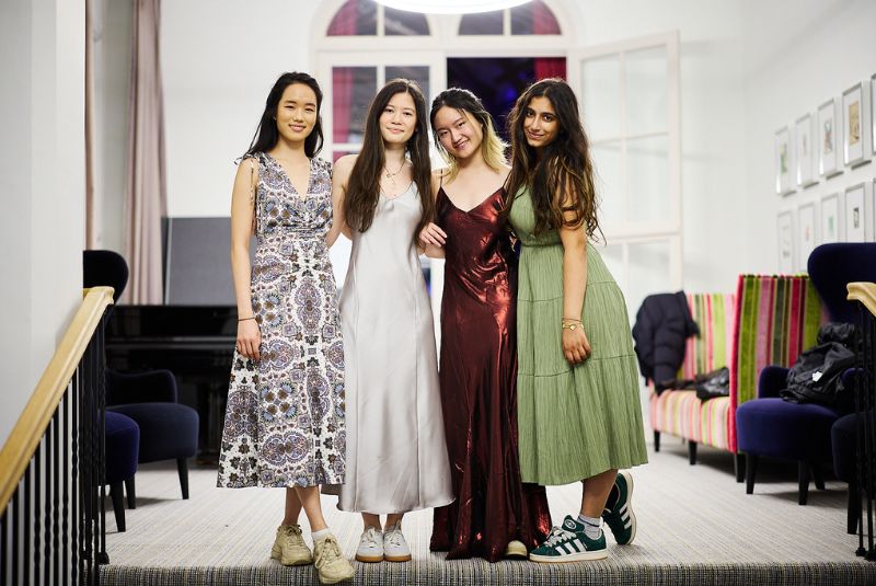 Wycombe Abbey pupils smiling in ball gowns.