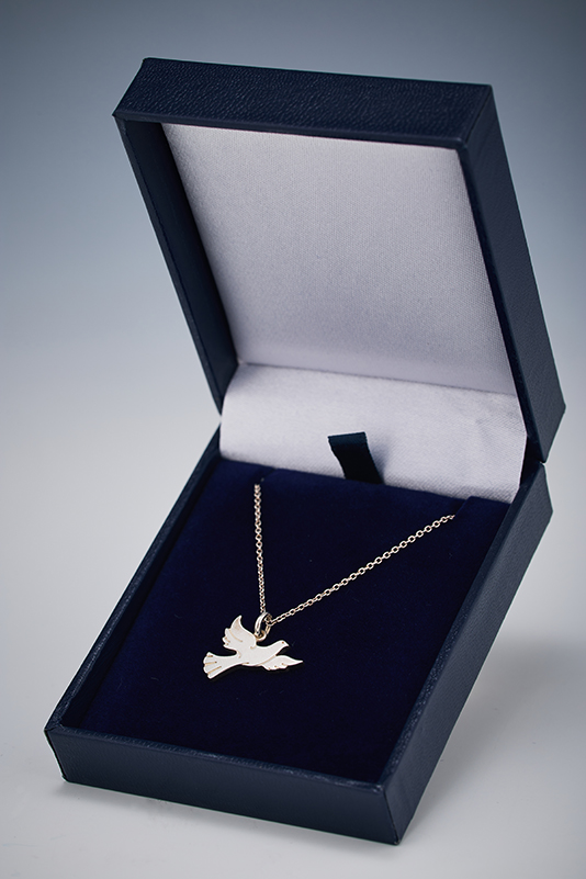 Silver Wycombe Abbey dove necklace in a navy box.