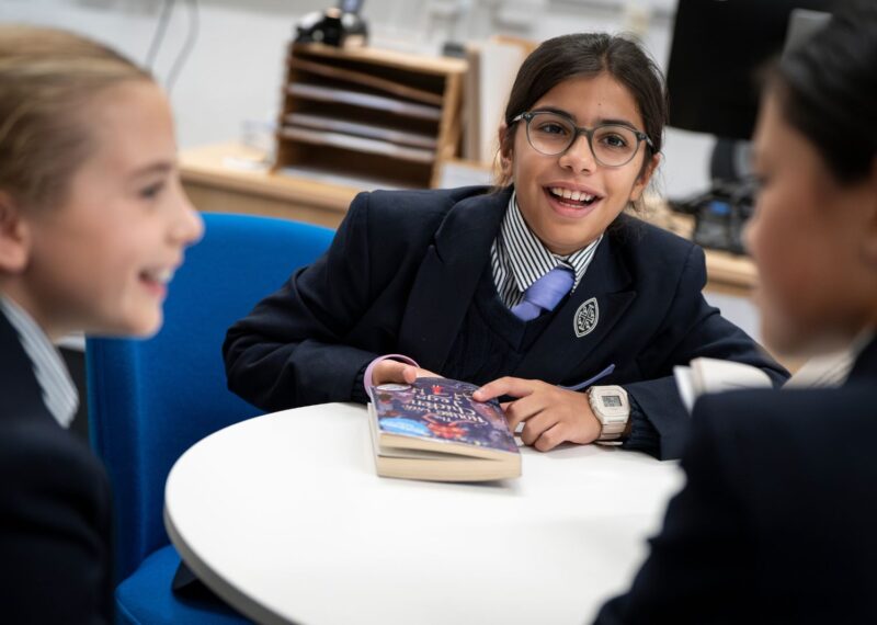 Pupils having a discussion around a table.