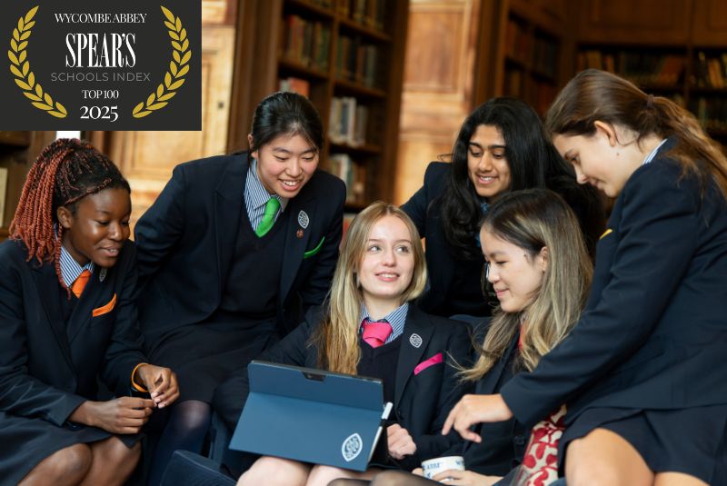 Wycombe Abbey pupil sat on a sofa whilst talking to each other.