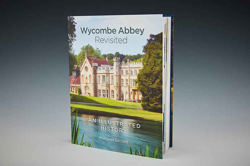 A hard back book, with the Abbey on the front cover, titled 'Wycombe Abbey Revisited'.